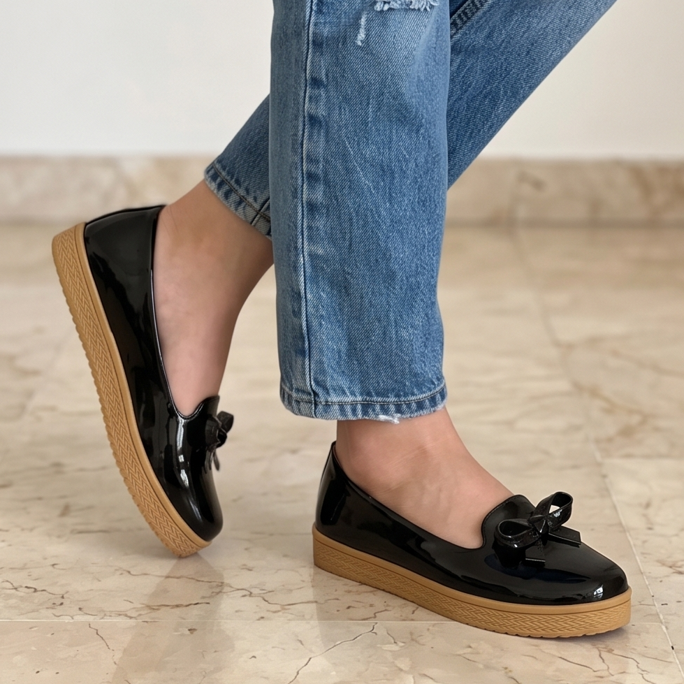 Zapatos bajos hechos en charol, decorados con un chongo