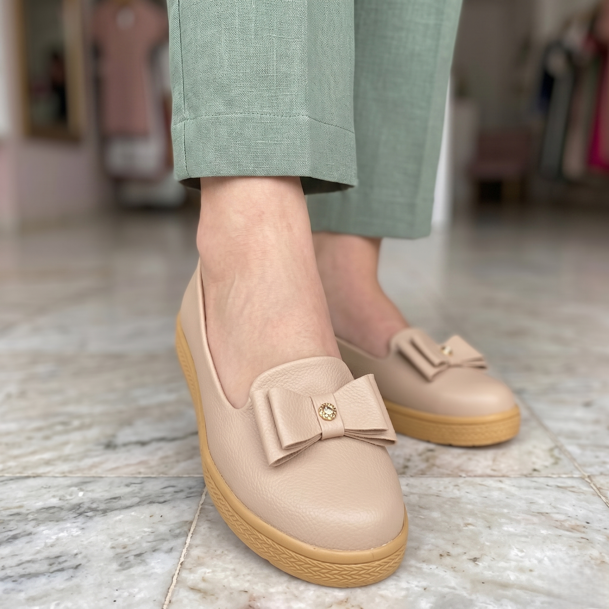 Zapato cerrado con un chongo enfrente, suela beige