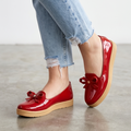 Zapatos bajos hechos en charol, decorados con un chongo